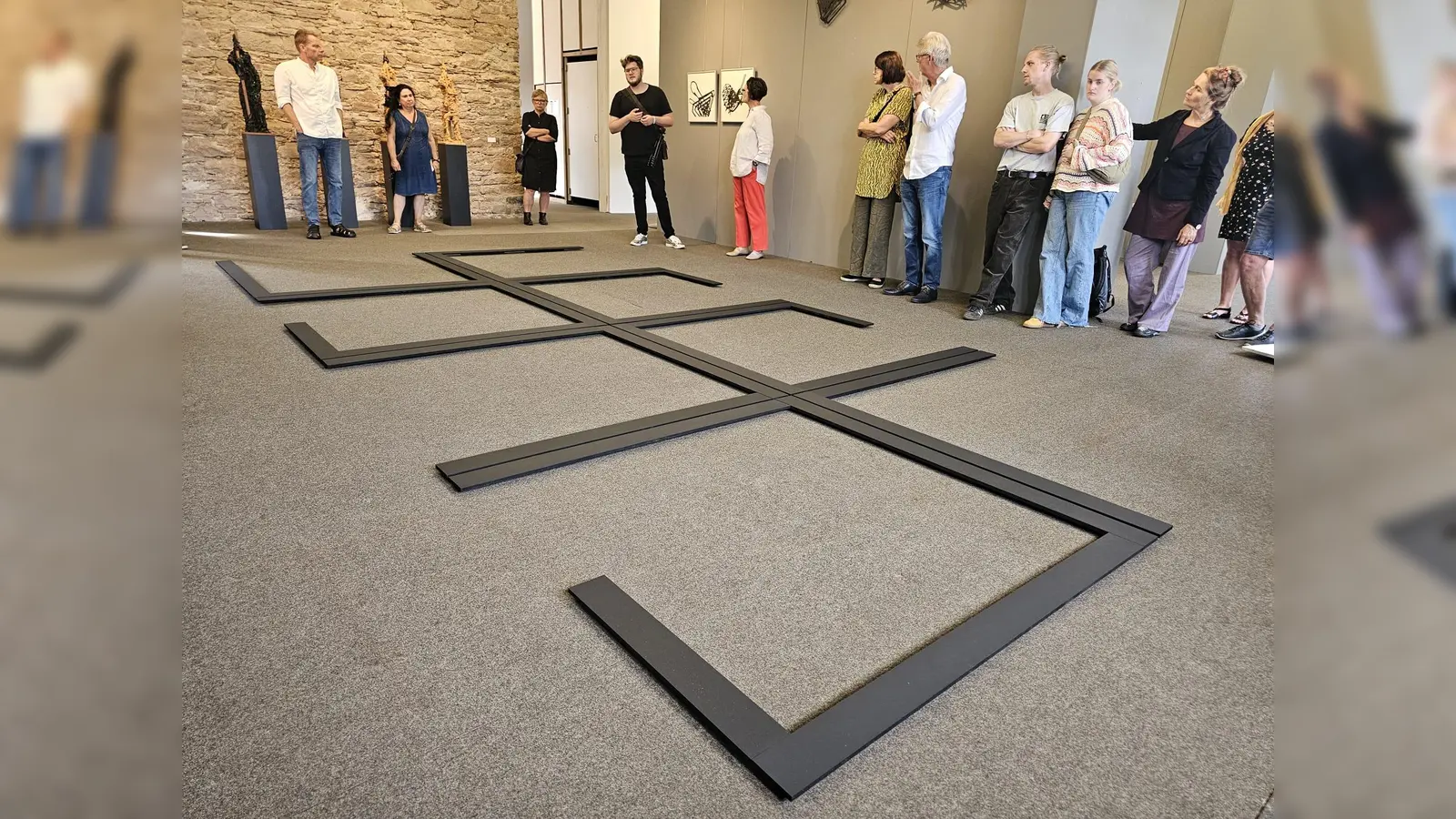 Philipp Valenta (Mitte), hier bei der Vernissage, wird auch am 6. Oktober seine Bodenarbeit „Cubicle“ erläutern. (Foto: Landkreis Holzminden)