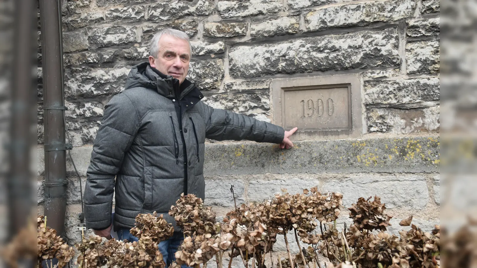 Ortvorsteher Bernhard Redeker zeigt die Jahreszahl der Grundsteinlegung im Mauerwerk der Kirche.  (Foto: Barbara Siebrecht)