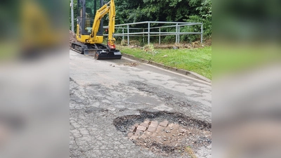 Die Deckschicht dieser Straße in Herstelle wurde stellenweise fortgespült. Der Unterbau des historischen Sandsteinpflasters wurde freigelegt.  (Foto: Barbara Siebrecht)