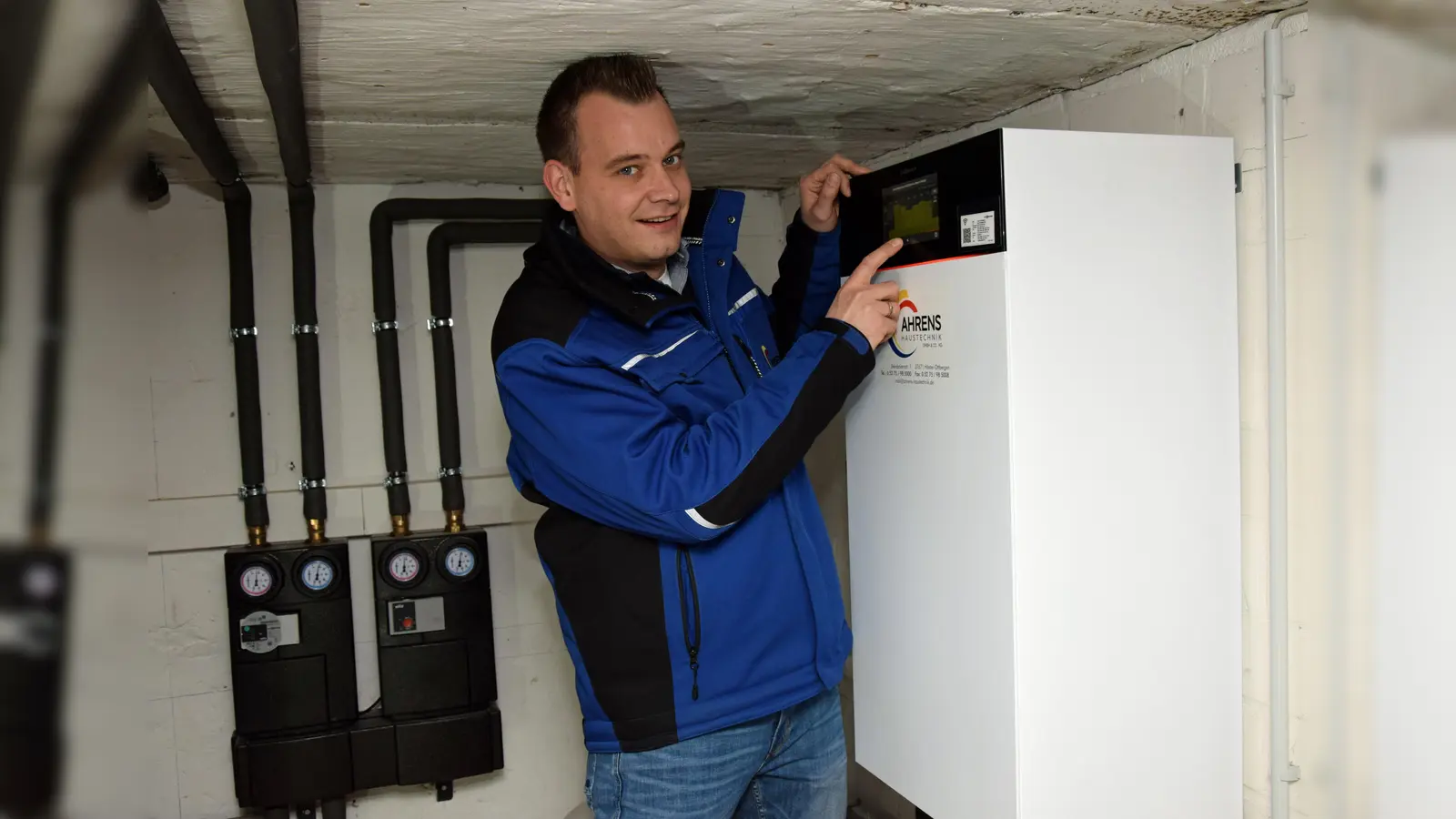 Moderne Heizung zum Energiesparen: Der Juniorchef und Ingenieur für Gebäudetechnik Heiner Ahrens überprüft im Keller die Funktionsweise der neuen Wärmepumpe. (Foto:  Kreishandwerkerschaft Höxter-Warburg/M. Schäfer)