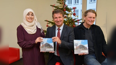 Pünktlich zur Vorweihnachtszeit präsentieren Layla Youssef vom Kulturbüro des Kreises Höxter, Landrat Michael Stickeln und Verleger Jörg Mitzkat das neue Jahrbuch des Kreises Höxter, das jetzt im Buchhandel erhältlich ist. (Foto: Kreis Höxter)