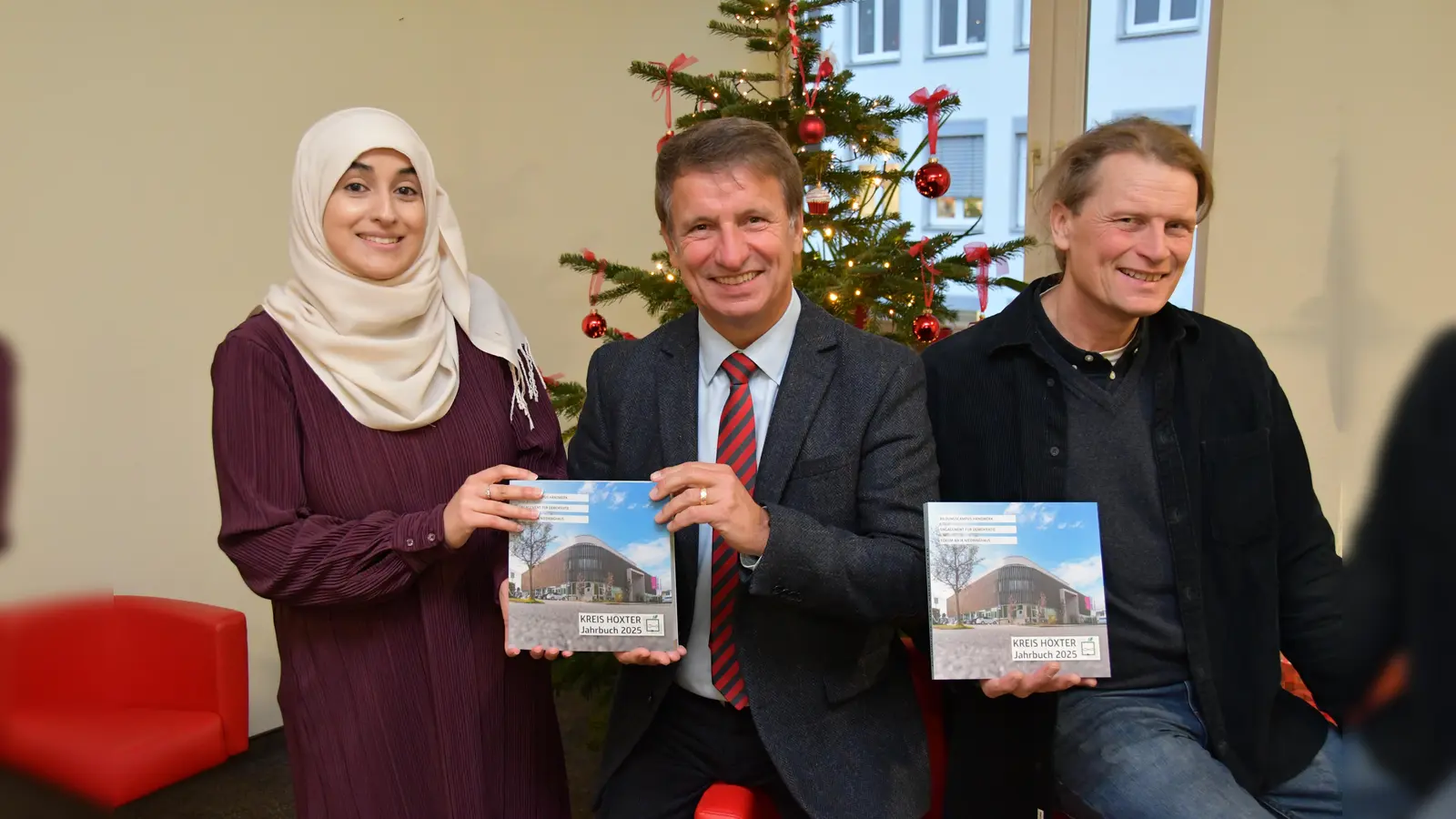 Pünktlich zur Vorweihnachtszeit präsentieren Layla Youssef vom Kulturbüro des Kreises Höxter, Landrat Michael Stickeln und Verleger Jörg Mitzkat das neue Jahrbuch des Kreises Höxter, das jetzt im Buchhandel erhältlich ist. (Foto: Kreis Höxter)