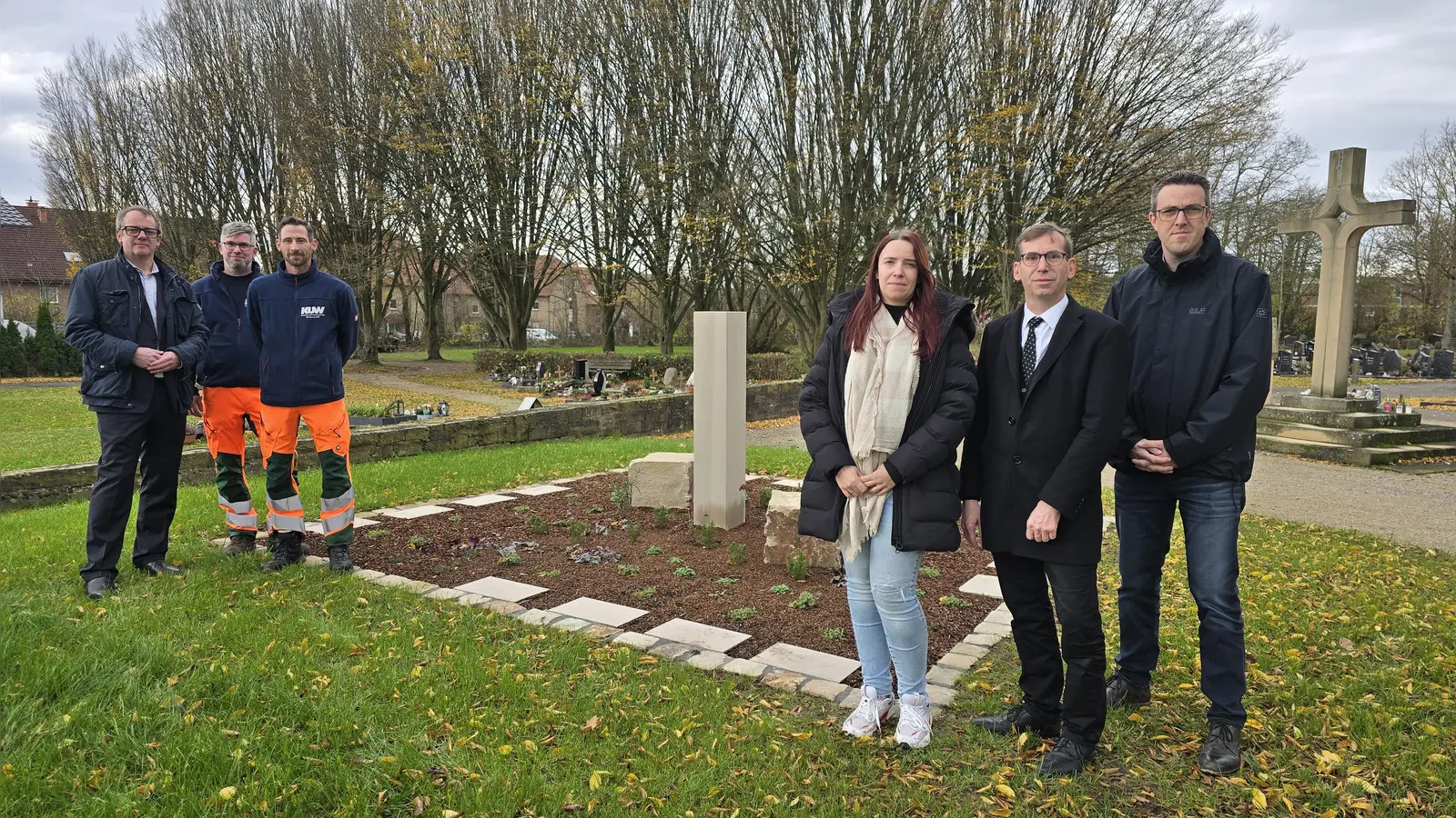 V.l.: Leander Sasse, Geschäftsführer des Kommunalunternehmens Warburg, Thomas Deist und Bernd Berlage (beide KUW), Denise Flinkmann (KUW – Friedhofsverwaltung), Bürgermeister Tobias Scherf und der erste Beigeordnete Andreas Niggemeyer vor einer großen Urnengemeinschaftsgrabanlage auf dem Warburger Stiepenfriedhof. (Foto: Hansestadt Warburg)