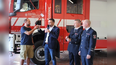 Symbolische Schlüsselübergabe: Sven Lang (l.) nimmt stellvertretend den Schlüssel für das neue Fahrzeug von Bürgermeister Torben Busse entgegen, daneben (2.v. rechts) Tobias Sommer, stellv. Stadtbrandinspektor, und Wehrführer Maximillian Wiegand. (Foto: Julia Sürder)