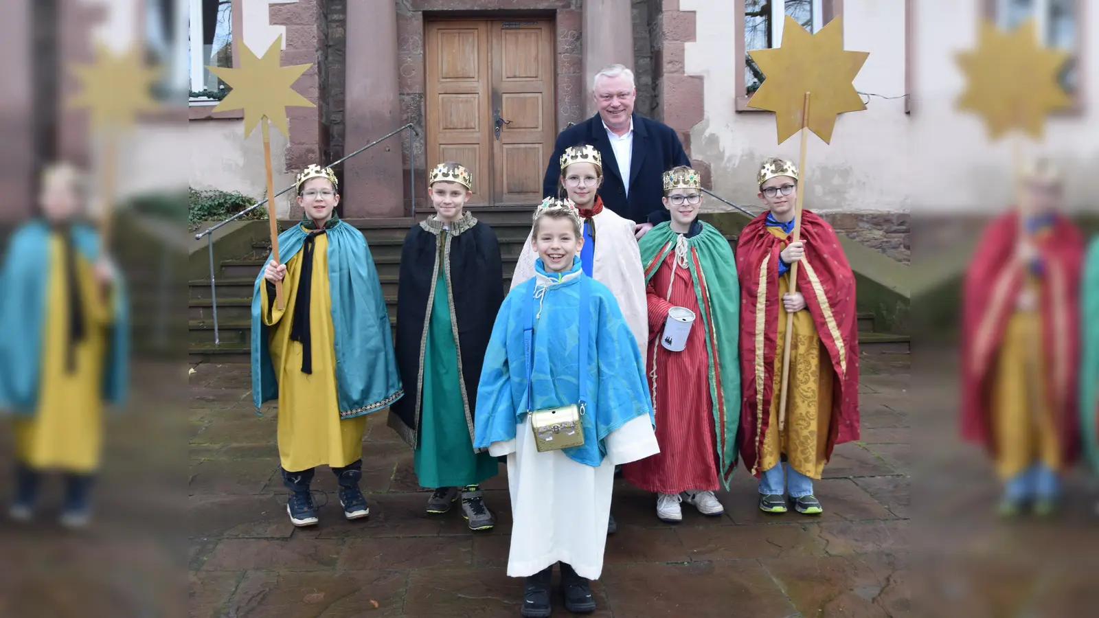 Bürgermeister Hartmann freut sich über den Besuch der Sternsinger; v.l. Justus, Theo, Benjamin, Philipp, Marlene und Henri. Den ersten Segensaufkleber brachten die Kinder an die Tür des Stadthauses an. (Foto: Stadt Höxter)