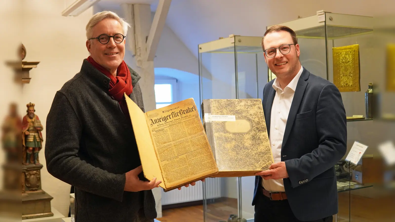 Archivar Dirk Brassel (links) und Alexander Kleinschmidt als Allgemeiner Vertreter des Bürgermeisters möchten auf den digitalen Zugang zum historischen Brakeler Zeitungsbestand hinweisen. (Foto: Stadt Brakel)