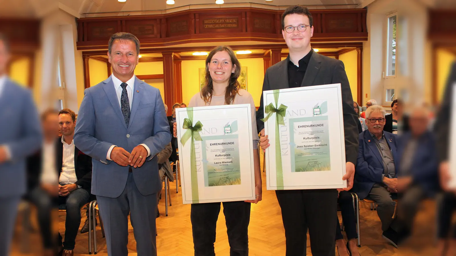 Großer Stolz und Freude: Landrat Michael Stickeln hat im feierlichen Rahmen in der Aula des Kreishauses den Kulturpreis und die Urkunden an Laura Wiemers und Joss Spieker-Siebrecht überreicht. (Foto: Kreis Höxter)