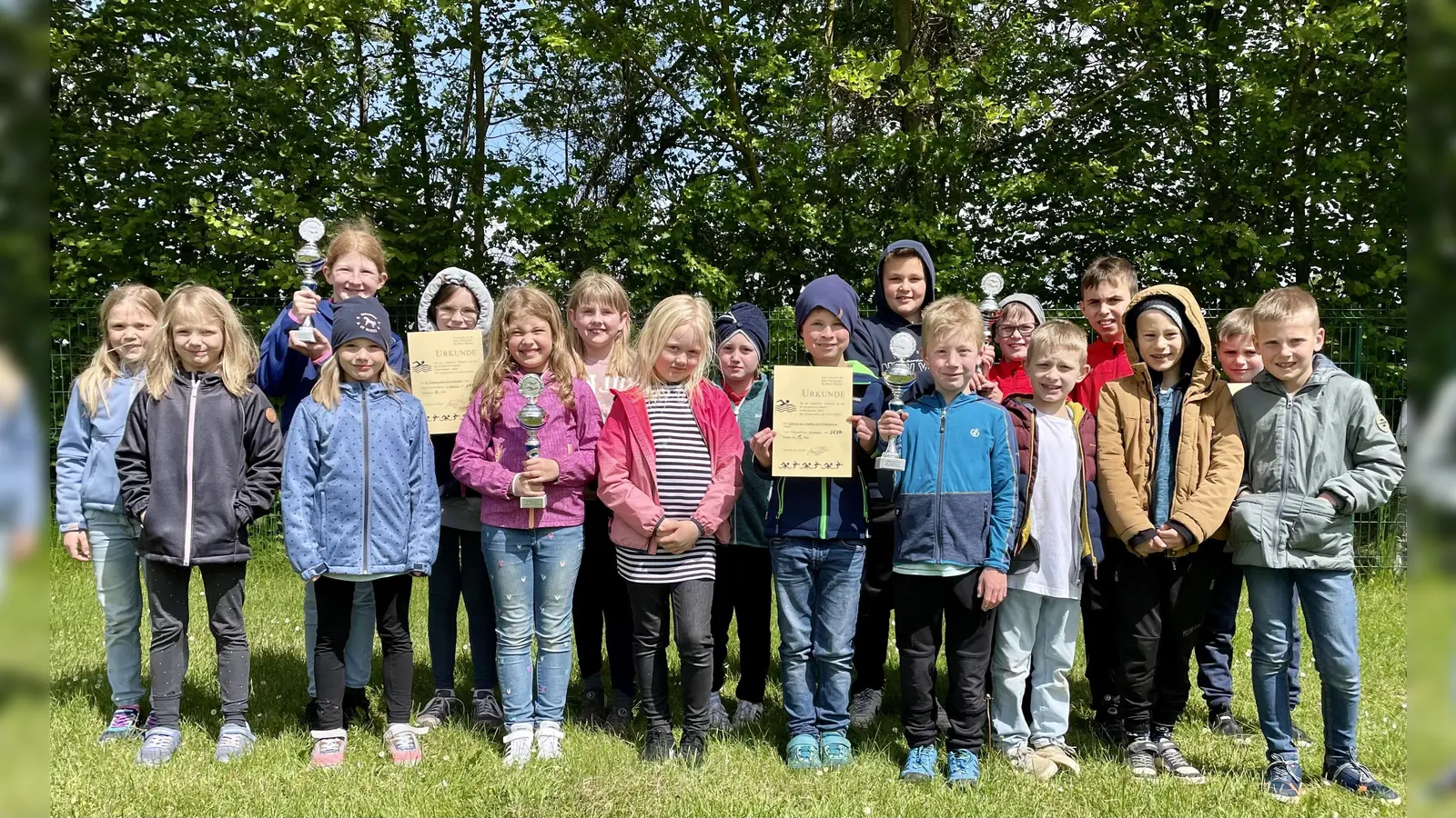 Die Mädchen und Jungen der Siegerteams präsentieren die Pokale: Zwei Titel gingen an die Grundschule St. Nikolai in Peckelsheim. Kreismeister sind zudem die Katholische Grundschule Borgentreich und die Katholische Grundschule Willebadessen geworden. (Foto: Kreis Höxter)